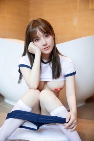 Brunette Asian teen flaunts her booty and breasts on the toilet